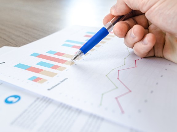 A hand with pen working on a chart